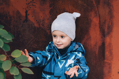 Child looks at a branch with leaves and reaches for it with his hands.environmental research concept