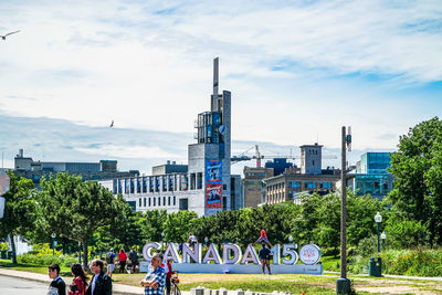 Group of people in park against buildings in city