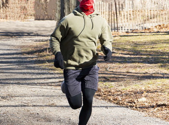 Rear view of man walking on footpath