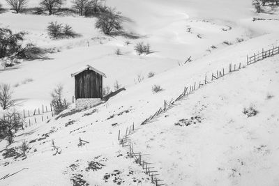 Scenic view of snow covered field by houses