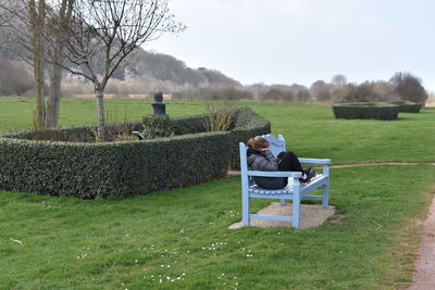Man sitting on bench in field