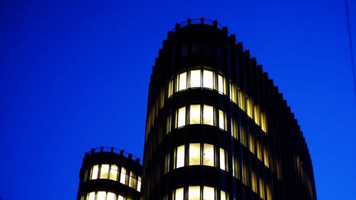 Low angle view of modern building against blue sky