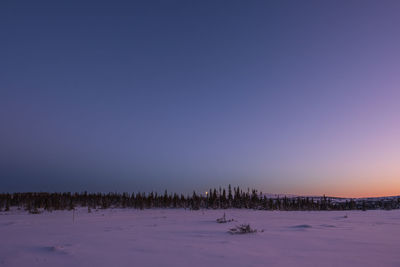 Scenic view of snow covered landscape against clear blue sky