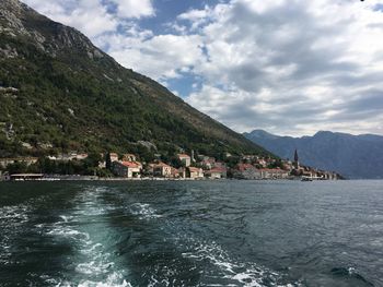 Scenic view of lake by mountains against sky