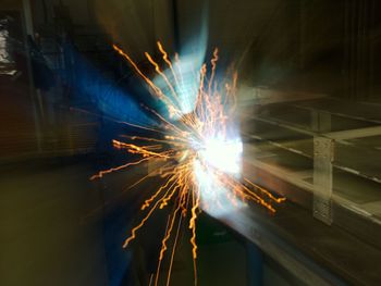 Man welding metal at night