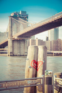 Bridge over river in city against sky