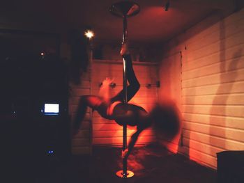 Full length of man wearing sunglasses against illuminated wall