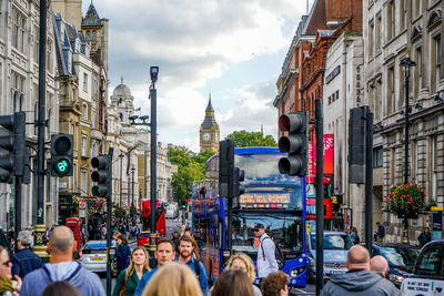 People walking on street in city against sky