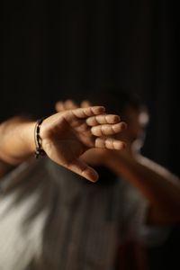 Low angle view of man showing stop gesture
