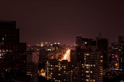 Illuminated buildings in city against sky at night