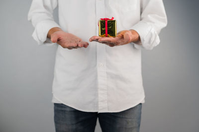 Midsection of man holding ice cream against white background