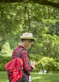 Man standing by tree against plants