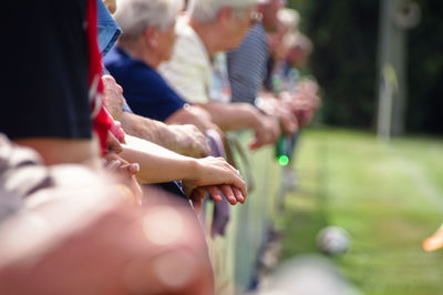 Midsection of people watching soccer match