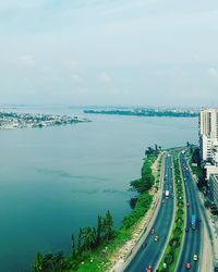 High angle view of city by sea against sky