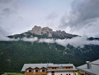 Scenic view of buildings and mountains against sky