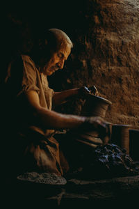 Side view of man working on rock