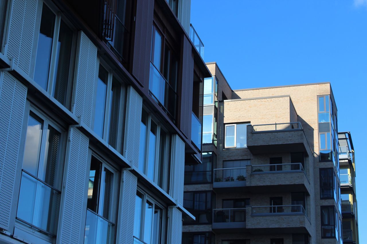 architecture, building exterior, built structure, low angle view, blue, clear sky, window, outdoors, day, no people, residential building, sky, fire escape