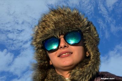 Portrait of man wearing sunglasses against blue sky