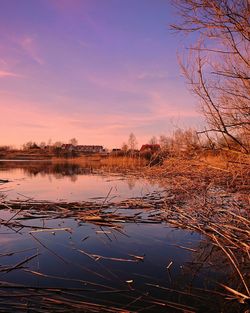 Scenic view of lake against sky at sunset