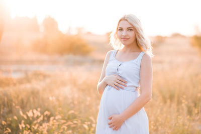 Pregnant woman standing in field