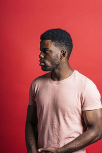 Portrait of young man against red background