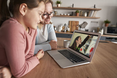 Grandmother and granddaughter talking on video call at home