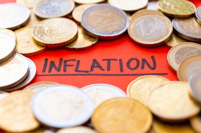 Word inflation on white paper, surrounded by euro coins. rising prices, economic repercussions.