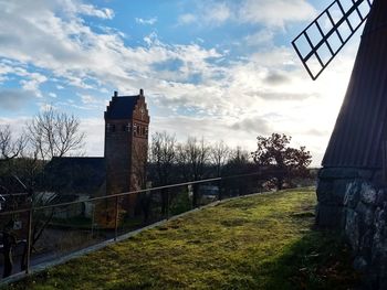 Tower amidst grass against sky