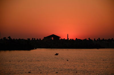 Scenic view of sea against orange sky