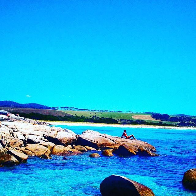 blue, water, clear sky, copy space, sea, leisure activity, rock - object, men, lifestyles, tranquility, scenics, tranquil scene, nature, beauty in nature, mountain, vacations, rock, rock formation