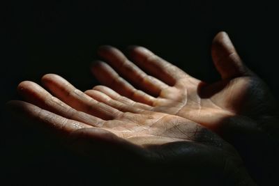 Cropped hands against black background