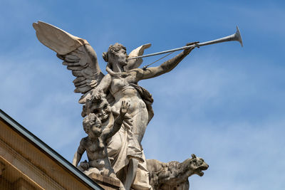 Low angle view of angel statue against sky