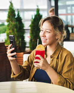 Portrait of young woman using mobile phone