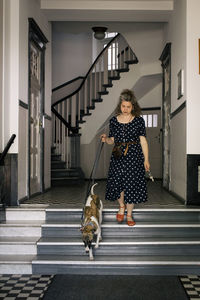 Woman moving down on steps with dog