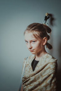 Close-up portrait of girl standing by wall