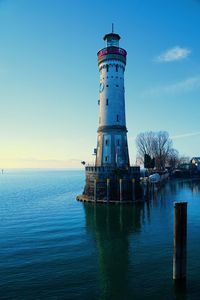 Lighthouse by sea against sky