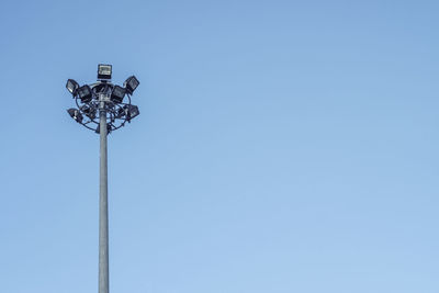 Low angle view of floodlights against clear blue sky