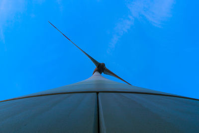 Low angle view of wind turbine against blue sky