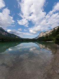 Scenic view of lake by mountains against sky