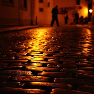 People walking on illuminated street at night