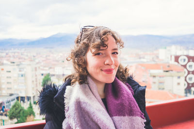 Portrait of young woman looking away against sky