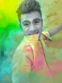Portrait of man holding multi colored umbrella