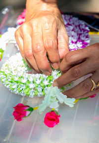 Close-up of hand holding bouquet of red rose