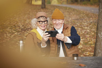Senior couple taking selfie in park
