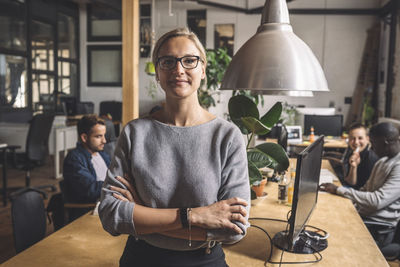 Portrait of businesswoman with arms crossed at workplace