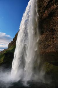 Scenic view of waterfall against sky