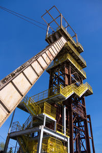 Low angle view of crane against clear blue sky