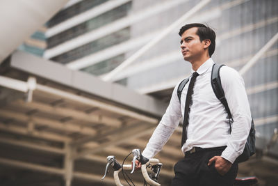 Young man riding bicycle on city