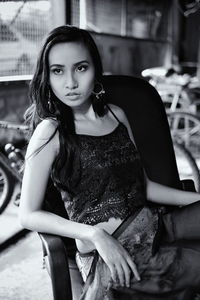 Portrait of young woman sitting outdoors