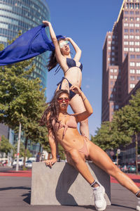 Fashionable young women wearing bikinis in city